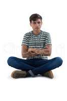 Teenage boy relaxing against white background