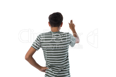 Teenage boy pressing an invisible virtual screen against white background