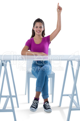 Teenage girl raising her hand against white background