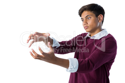 Teenage boy pretending to hold an invisible object