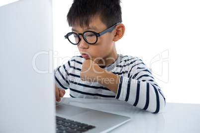 Boy using laptop against white background