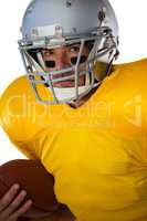 Portrait of determined football player wearing helmet holding ball
