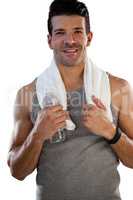 Portrait of smiling tired sportsman with towel and bottle