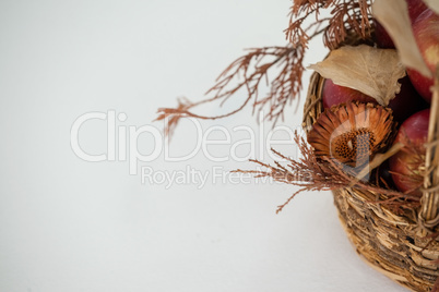 Close-up of red apples with autumn leaves in wicker basket