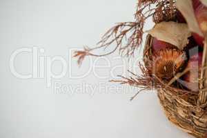 Close-up of red apples with autumn leaves in wicker basket