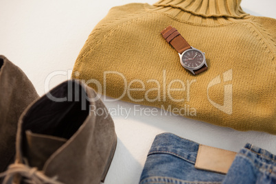 Pair of shoes, sweater, jeans and watch on white background