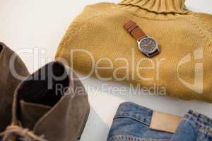 Pair of shoes, sweater, jeans and watch on white background