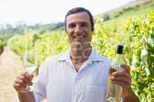 Portrait of smiling vintner examining wine