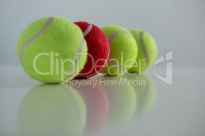 Red and fluorescent tennis ball arranged in row