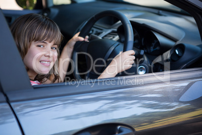 Happy teenage girl driving a car