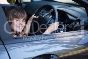 Happy teenage girl driving a car