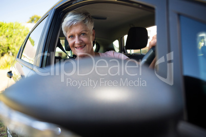 Happy senior woman driving a car