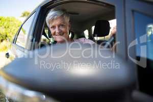 Happy senior woman driving a car