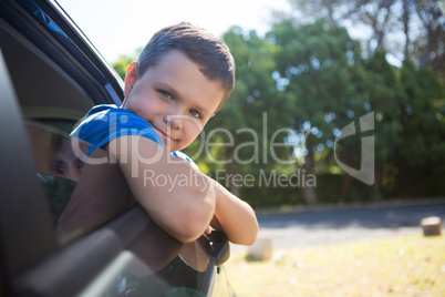 Teenage boy leaning out of car window