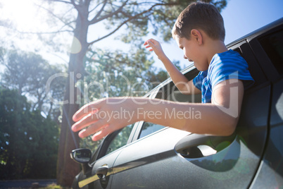 Teenage boy looking from open car window