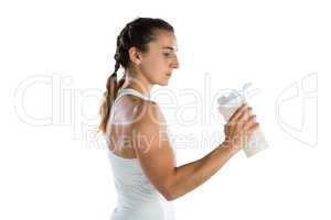 Side view of female athlete holding bottle
