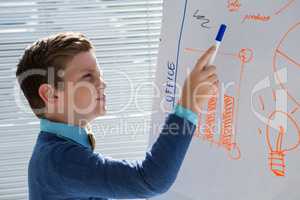 Boy as business executive presenting on white board