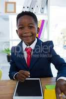 Boy as business executive smiling while sitting in office
