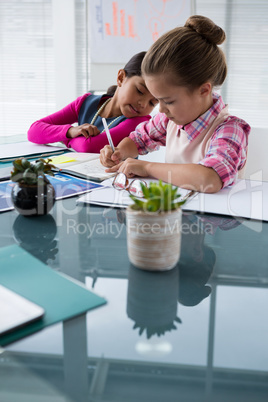 Kids as business executive writing in book