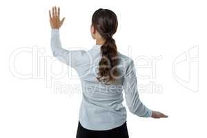 Female executive pretending to touch an invisible screen against white background
