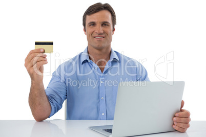 Male executive holding debit card against white background