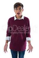 Shocked teenage boy standing against white background