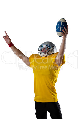 American football player with arms outstretched holding ball