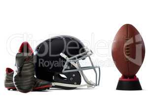 Close up of sports shoes and helmet by American football on tee