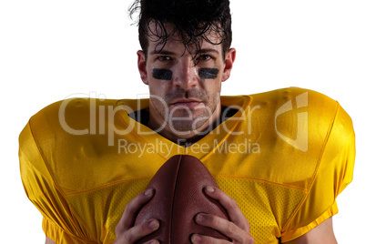 Portrait of determined American football player holding ball