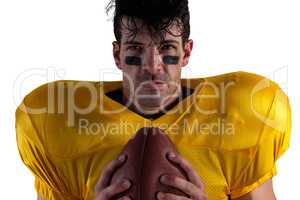 Portrait of determined American football player holding ball
