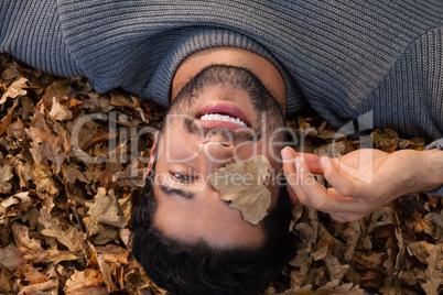 Overhead of man lying on autumn leaves