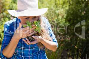 Woman smelling sapling in garden