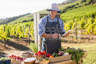 Happy man using digital tablet at vegetable stall