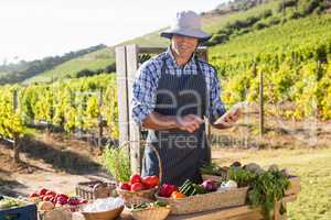 Happy man using digital tablet at vegetable stall