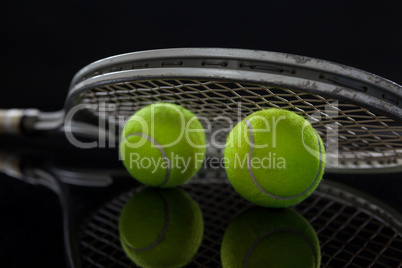 Close up of fluorescent yellow tennis balls with racket