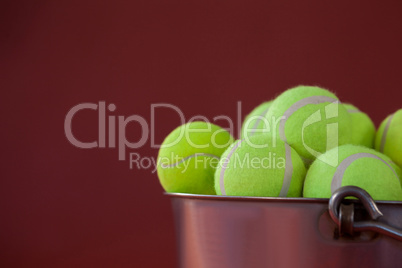 Close up of fluorescent yellow tennis balls in silver bucket