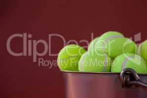 Close up of fluorescent yellow tennis balls in silver bucket