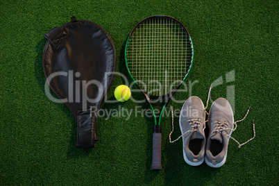 Directly above shot of racket with ball and sports shoes