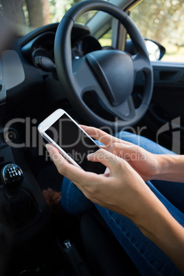 Woman using mobile phone in the car