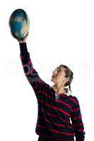 Female athlete with arms raised holding rugby ball