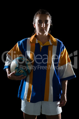 Portrait of female athlete in sports clothing holding rugby ball