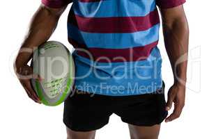 Mid section of male player holding rugby ball