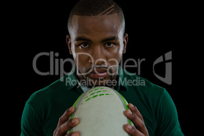 Close up portrait of confident male athlete with rugby ball