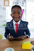 Boy as business executive holding digital tablet