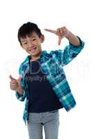 Boy forming a finger frame against white background