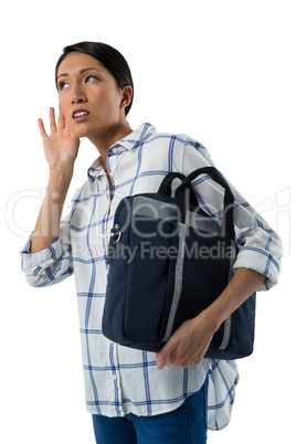 Female executive with briefcase listening secretly with hands behind her ears