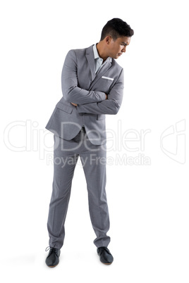 Businessman standing with arms crossed on white background