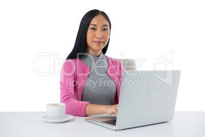 Female executive using laptop against white background