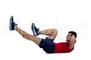 Side view of sports player exercising while lying down