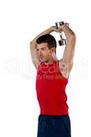 Determined sports player exercising with dumbells